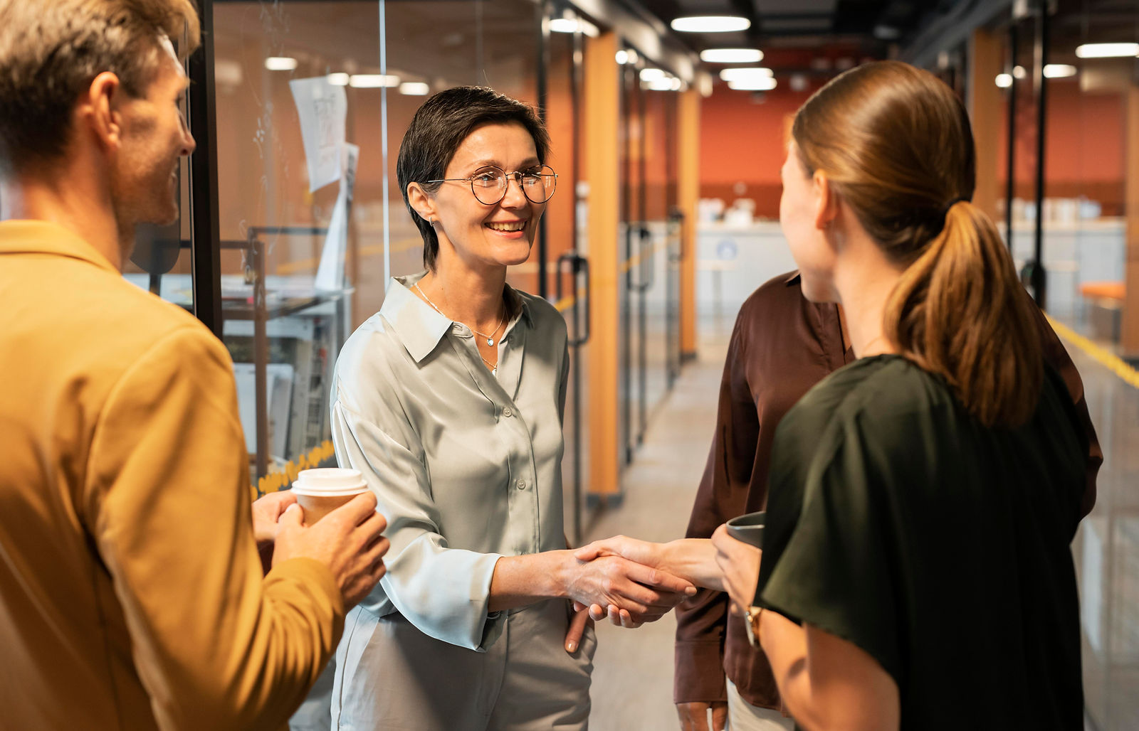 Close-up of women shaking hands at work after a promotion